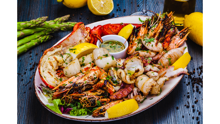 Seafood platter. Grilled lobster, shrimps, scallops, langoustines, octopus, squid on white plate.