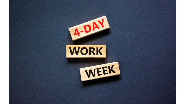 4-day work week symbol. Concept words 4-day work week on wooden blocks on beautiful black table black background. Copy space. Business and 4-day work week and short workweek concept.