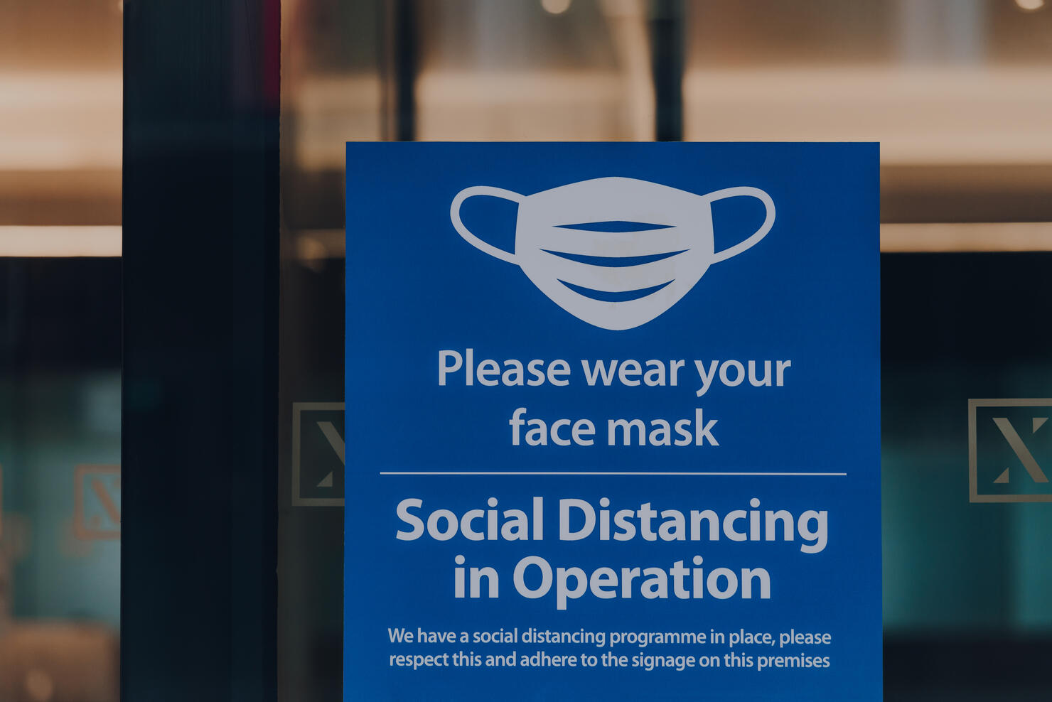 Please wear your face mask sign at the entrance of an office building in London, UK.