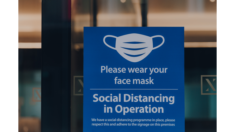 Please wear your face mask sign at the entrance of an office building in London, UK.
