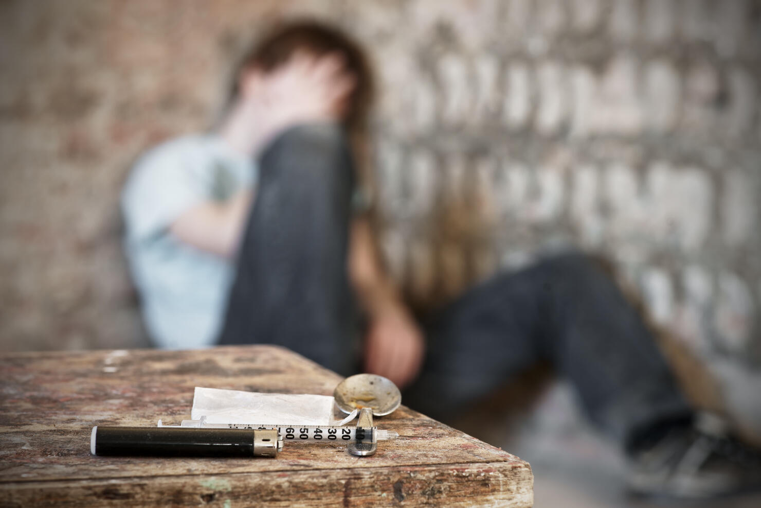 Drug paraphernalia with blurred addict behind
