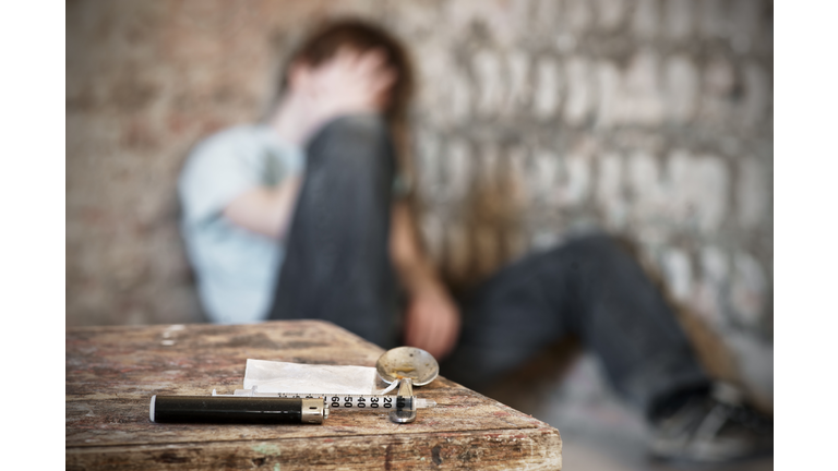 Drug paraphernalia with blurred addict behind
