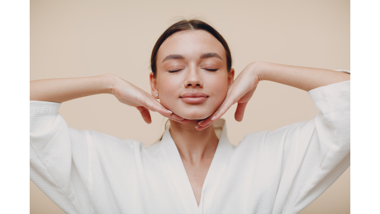 Young woman doing face building facial gymnastics self massage and rejuvenating exercises