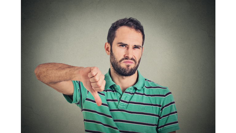 angry, unhappy man showing thumbs down sign