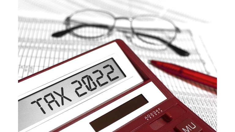 Word Tax 2022 on calculator. Glasses, pen and the calculator on documents. The concept of financial stability, Income Statement.