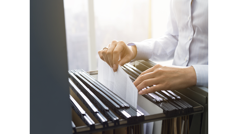 Office clerk searching files in the filing cabinet