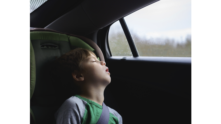 Boy sleeping while traveling in car