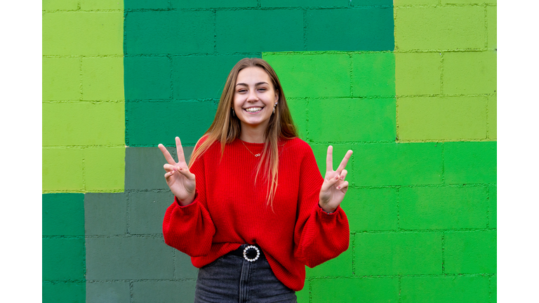 Teenage Blonde Girl With A Red Sweater. Attitude And Gestures Of Happiness And Positivity.