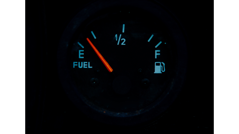 The fuel gauge on the black background showing that the tank is almost empty and it is a time to refuel