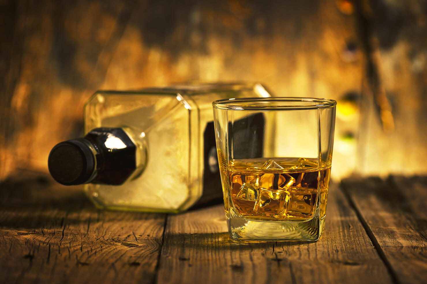 A Glass of whiskey and empty Bottle of whiskey
