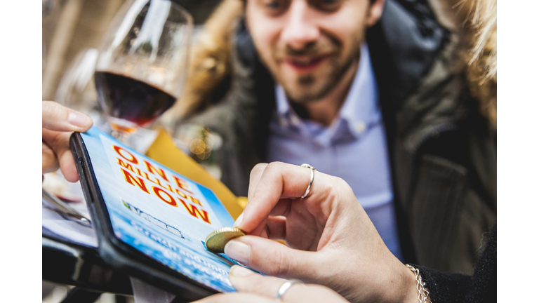 Friends playing with Lottery scratch game ticket