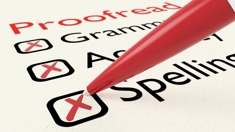 Checklist of proofreading characteristics grammar accuracy and spelling on paper crossed off by a red pen