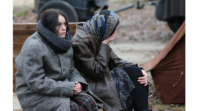 Tired women are sitting in the cold. Refugees. Refugees