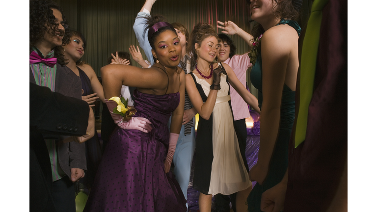Teenagers dancing together at prom