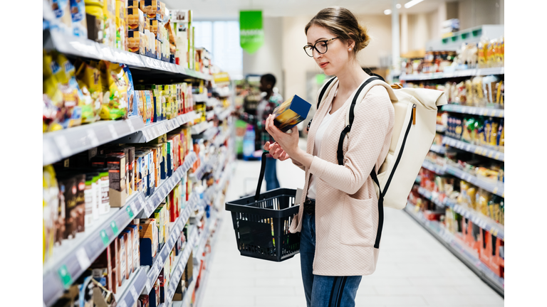 Woman Reading Food Item Label In Supermarket