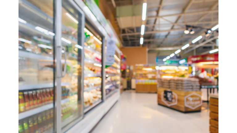 supermarket aisle with commercial refrigerators freezer showing frozen foods abstract blur background