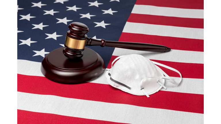 N95 face mask, gavel and United States of America flag. Concept of face covering mandate, ordinance, lawsuit, freedom, constitutional rights during Covid-19 coronavirus pandemic