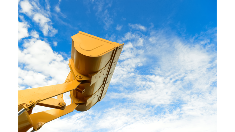 loader part of the backhoe loader tractor machine in yellow color with blue sky in background.backhoe loader while working in industry