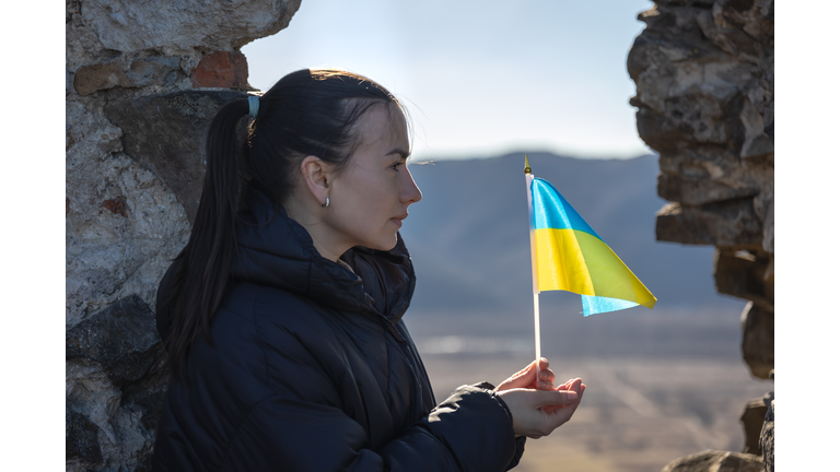 A young woman with the flag of Ukraine in her hands.