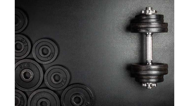 Gym dumbbells with black metal weights 1kg and 2kg on black background with copy sapce, Photograph taken from above.