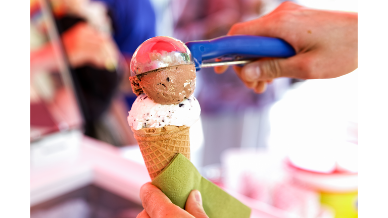 Serving ice cream scoops in a cone.