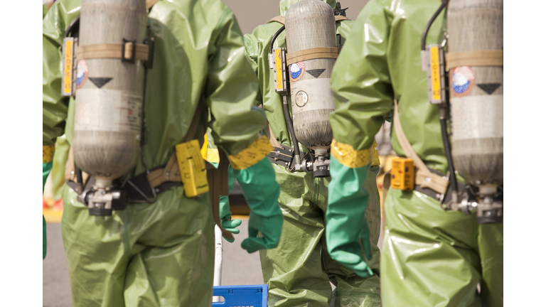 Rear view of HazMat firefighters with air tanks