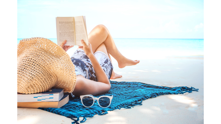 Woman  reading a book on the beach in free time summer holiday