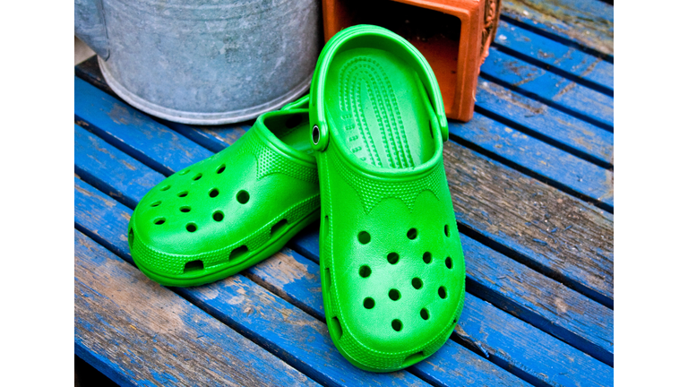 Green Garden Clogs On A Blue Table