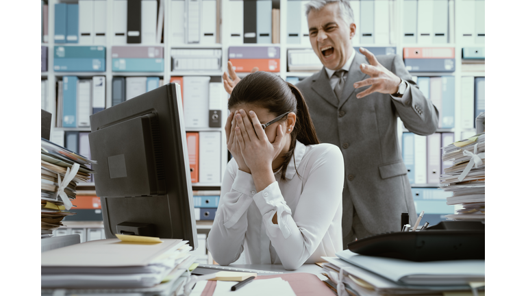 Angry boss yelling at his young employee