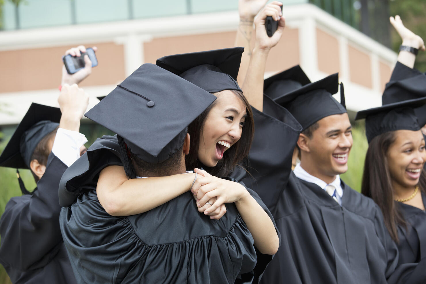 Graduates hugging outdoors