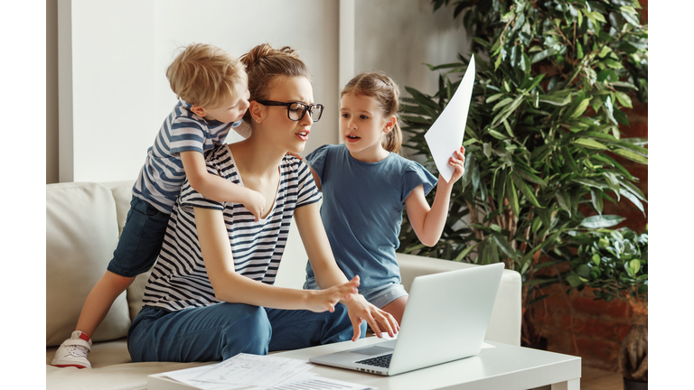 Stressed woman with kids working from home