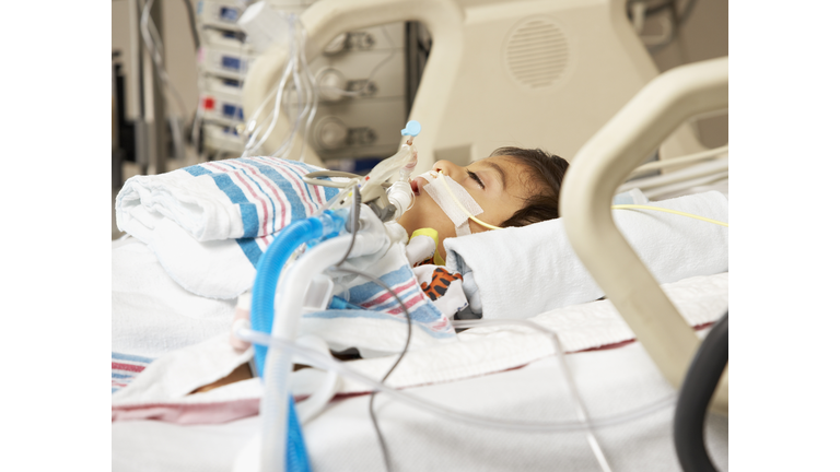 Hispanic boy in Intensive Care Unit bed