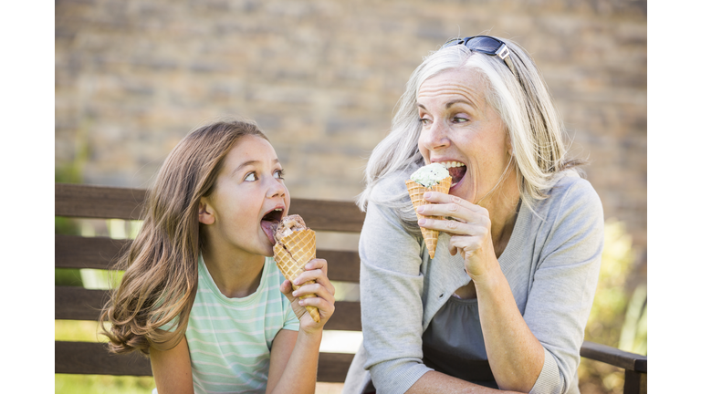 Caucasian grandmother and granddaughter eating ice cream