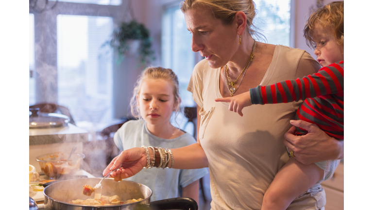 Caucasian mother and children cooking in kitchen