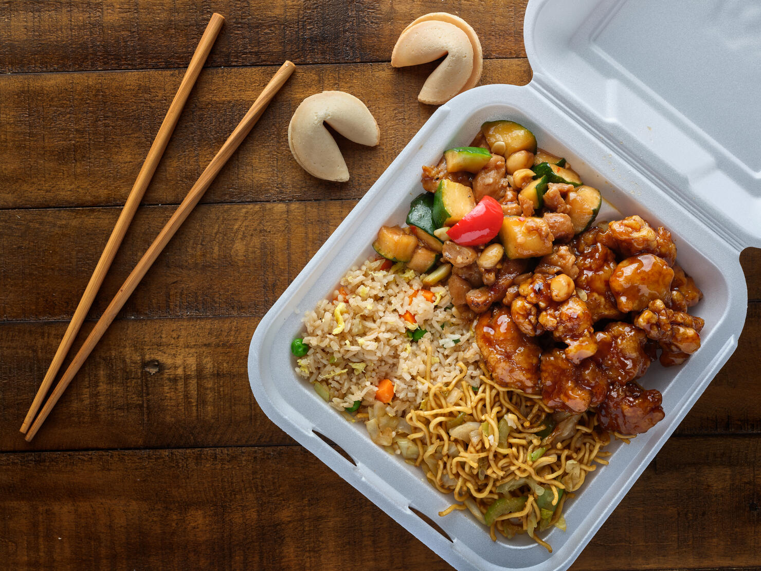 chinese take out with fried rice and general tsos chicken on table top