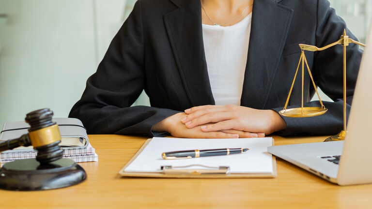 Lawyer who works or reads law books at work in the concept office, a lawyer counseling with hammers and scales with a laptop on the table.