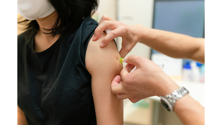 Photo of a woman being vaccinated by a doctor