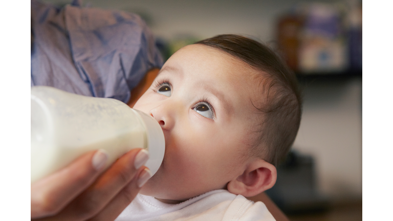 Baby girl drinking bottle of milk