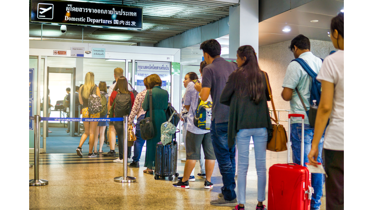 People waiting in line for security check at airport domestic departures