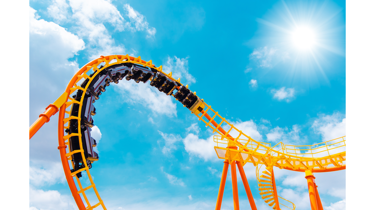 roller coaster high in the summer sky at theme park most excited fun and joyful playing machine