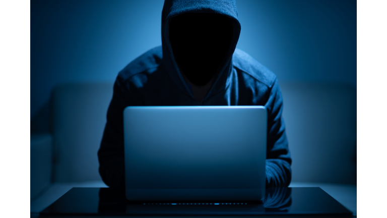 Hacker dark face using laptop