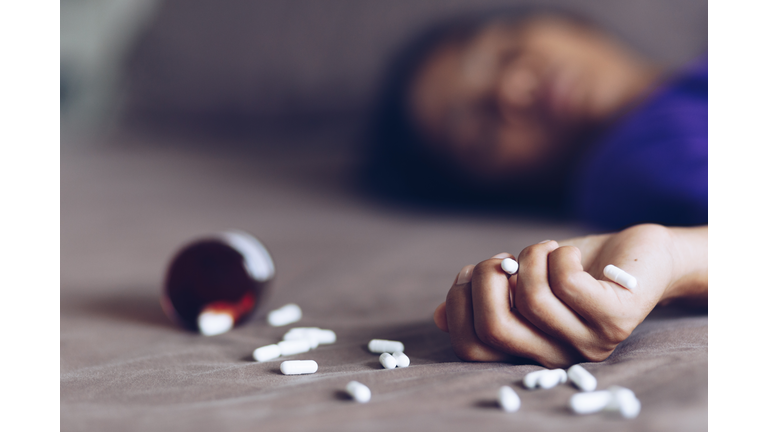 Close-Up Of Woman With Medicines Lying At Home