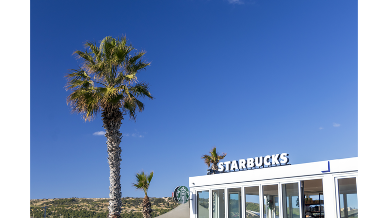 Starbucks coffeehouse chain shop exterior under palm tree and blue sky in maltese paradise island