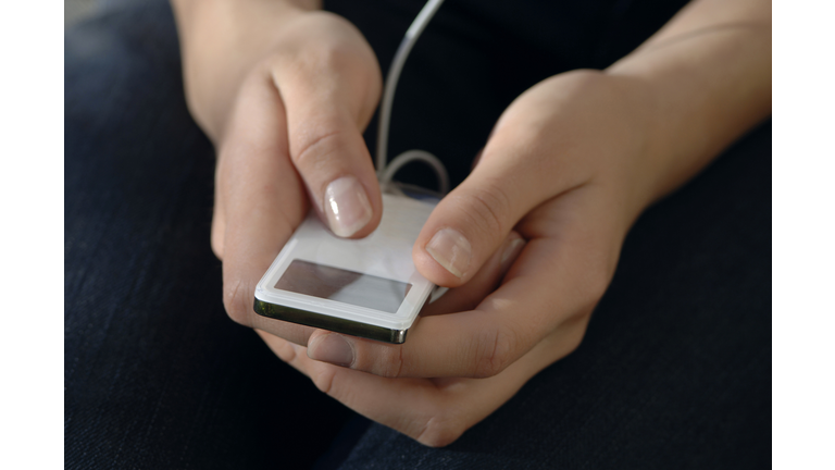 Woman using mp3-player, close-up