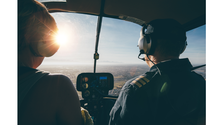 Two pilots in a helicopter flying on a sunny day