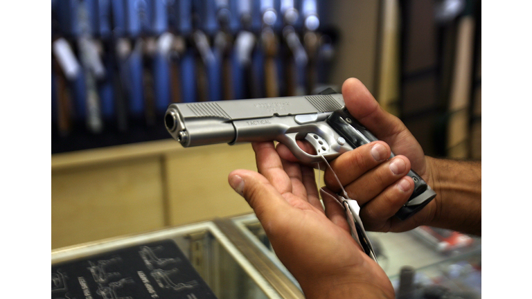 A man chooses a gun at the Gun Gallery i...