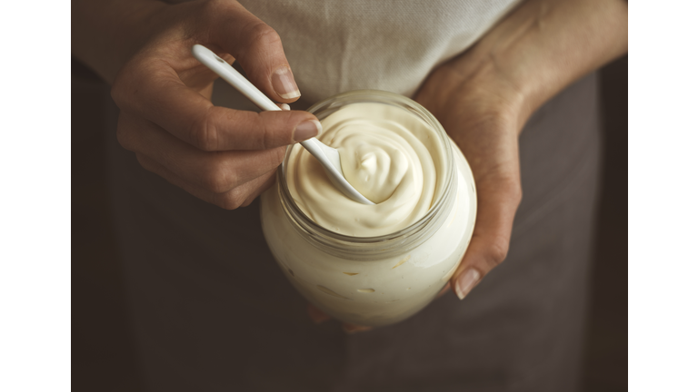Glass jar of mayonnaise with a spoon.
