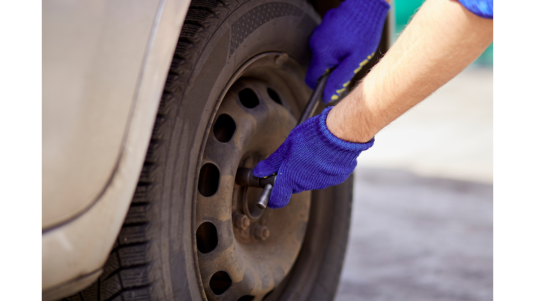 Changing tires on the car with tools. Seasonal needs for safety. Safety concept. Lifestyle photography
