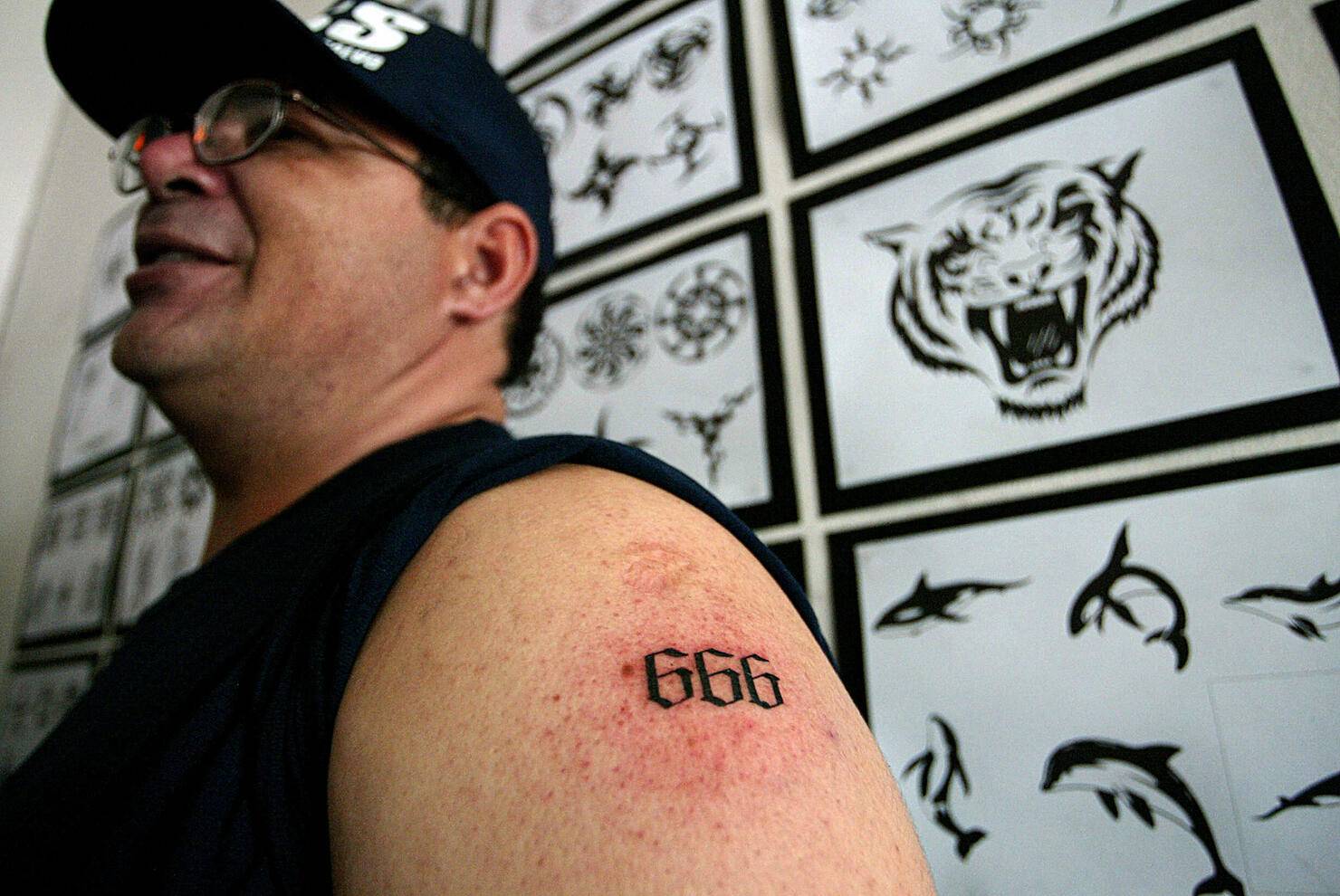 A man shows a tattoo with the number 666...