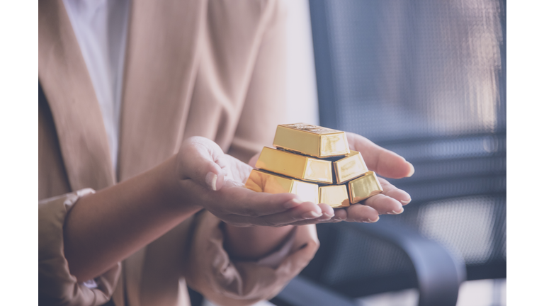Woman holding gold bullion ,business and trading concept